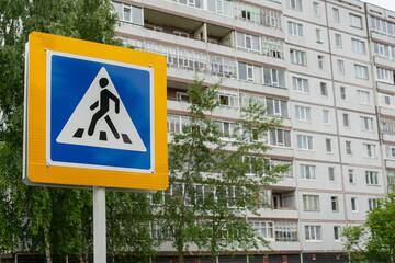 Pedestrian crossing sign on the background of a multi-storey building