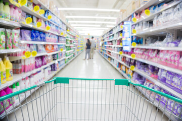 Blurred food and drink on shelf in super market with cart