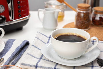 White cup of coffee on wooden kitchen table