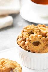Shortbread in a white ceramic plate on a light table. A plate of cookies on the gray kitchen table. Cookies close up