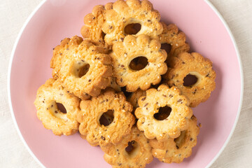 Shortbread in a pink ceramic plate on a light table. A plate of cookies on the table close-up. Top view with space for text