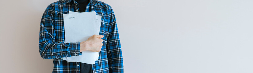 office worker holding paper documents standing against the wall with copy space