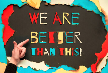 Paper hole with burned edges, flat lay on paper, colorful paper text We Are Better Than That. Hand...