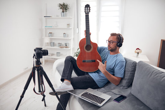 Guitarist making video lessons and tutorials for internet vlog website classes.