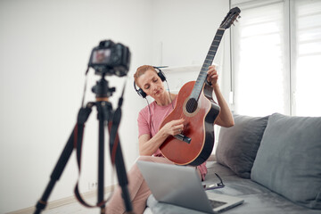 Guitarist making video lessons and tutorials for internet vlog website classes.