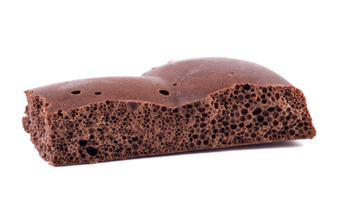 Milk chocolate isolated. Porous chocolate closeup. Sweet dessert on white background