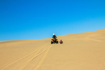 Quad driving people - two happy bikers in sand desert dunes, Africa, Namibia, Namib, Walvis Bay,...