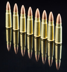 metal cartridges for hunting automatic weapons on a black background with a reflection