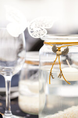 Festive dining table setting, with candles in glass jars, hearts and colors, vintage crockery and cutlery, closeup. High quality photo