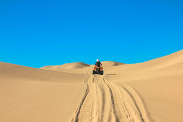 Fototapeta na wymiar Quad driving people - one happy biker in sand desert dunes, Africa, Namibia, Namib, Walvis Bay, Swakopmund.