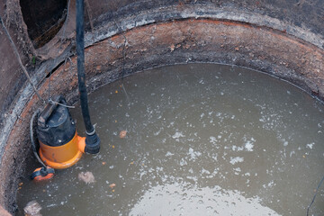 close-up drain pump in a cesspool filled with contaminated water with feces