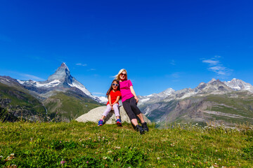 Fototapeta premium Mother and daughter on top of a mountain. The concept of travel, lifestyle