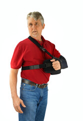 Middle aged man wearing a shoulder surgery sling with abduction pillow to keep his arm in the proper position during recovery and healing after his operation. - 355465446