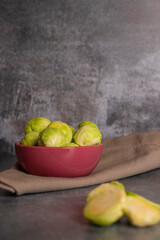 Fresh brussels sprouts served in bowl and with marbled gray background