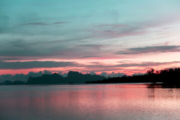 Beautiful purple pink sunset sky with  dark cloud on tropical summer evening twilight horizon over calm sea water surface & ocean wave at island paradise, travel concept         