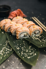 sushi rolls with rice and fish, soy sauce on a dark stone background concept of sushi restaurant summer mood 