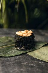 sushi rolls with rice and fish, soy sauce on a dark stone background concept of sushi restaurant summer mood 