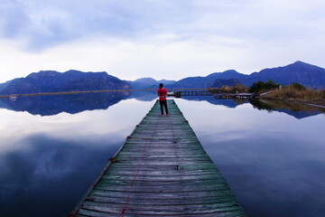 a young man on the wooden pier at the lake.