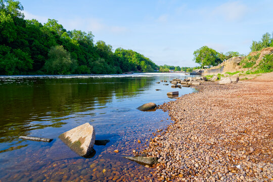 The rocky shore of the River Trent near Gunthorpe lock and weir on a spring morning