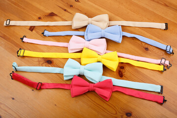 Set of multicolored bow tie on a wooden background. Background for sale. Place for text. Top view. Lots of colorful bow ties.