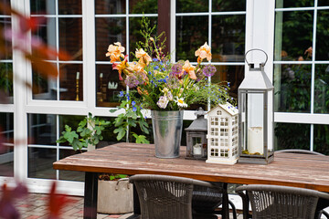 table in garden of country house. candlesticks and bouquet of flowers.