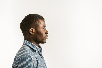 Young African man on white background. Profile view of serious Afro American student or businessman looking at right side with textspace or copy space. Toned image. - Powered by Adobe