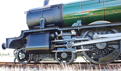Fototapeta na wymiar Closeup of wheels and con rods of renovated steam engine in England