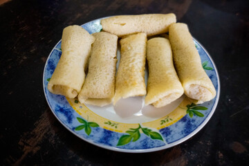 Dadar gulung/kuih ketayap is a popular traditional kue of sweet coconut pancake. It is often described as an Indonesian coconut pancake. Isolated on white background. 