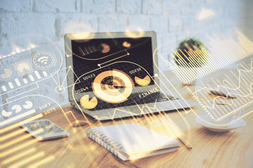 Computer on desktop in office with technology theme hologram. Multi exposure. Tech concept.