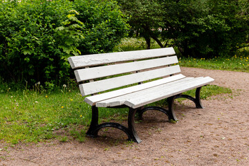 Empty white bench in a green park