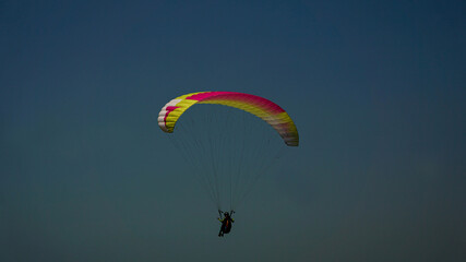 Paragliding flying in the blue sky.