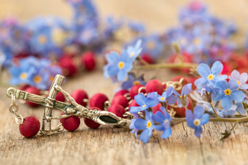 Forget-me-not flowers and Christian cross with rosary