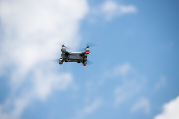 青空に飛んでいる小型ドローン