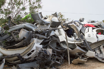 Scrapyard heap of plastic fenders from cars and motorcycles