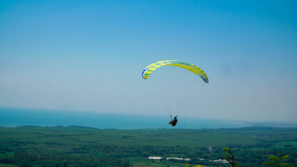 Paragliding flying in the blue sky.