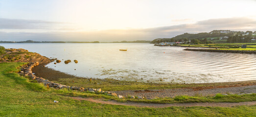 Norwegian fjords sea bay sunset landscape with summer meadow flowers, Norway
