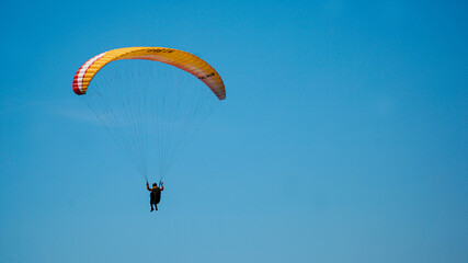 Paragliding flying in the blue sky.