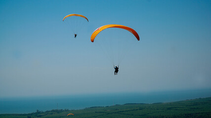 Paragliding flying in the blue sky.