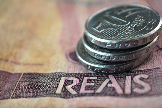 50 centavos coins on top of Brazilian real banknotes