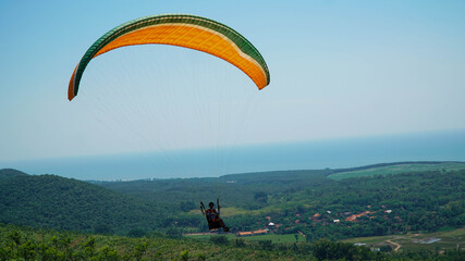 Paragliding flying in the blue sky.