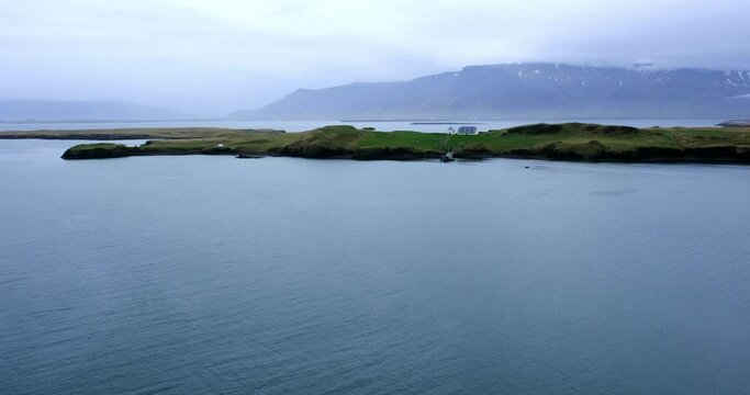 Panoramic view of Videy in Reykjavik and snow capped mountain, The Peace Tower is on this island.