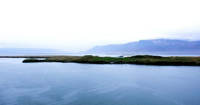 Panoramic view of Videy in Reykjavik and snow capped mountain, The Peace Tower is on this island.