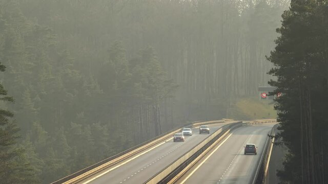 Cars Driving Highway Overpass In Forest at Sunset in Poland