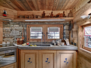 interior shot of a rustic kitchen in foreground the marble sink and the faucet  instead the wall are made of stones