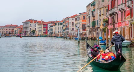 Poster Venetian gondolier punting gondola through green canal waters of Venice Italy © muratart