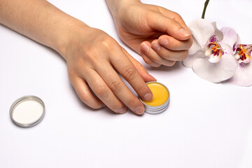 Female hands and natural wax cuticle oil. Nail care at home.