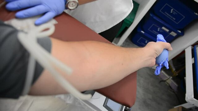 Close Up Arm Of A Man Who Donates Blood. Male Donor Gives Blood In A Mobile Blood Donation Center. COVID 19 Plasma Donation.