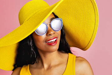 Close up portrait of a young smiling woman with summer hat and sunglasses