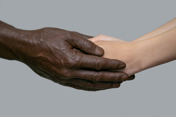 Black male hands hold white female human hands in their palms. The concept of inter-racial...