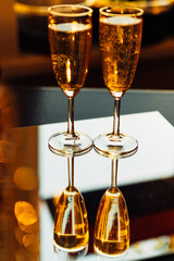 glass of champagne with splashing bubbles in the setting sun